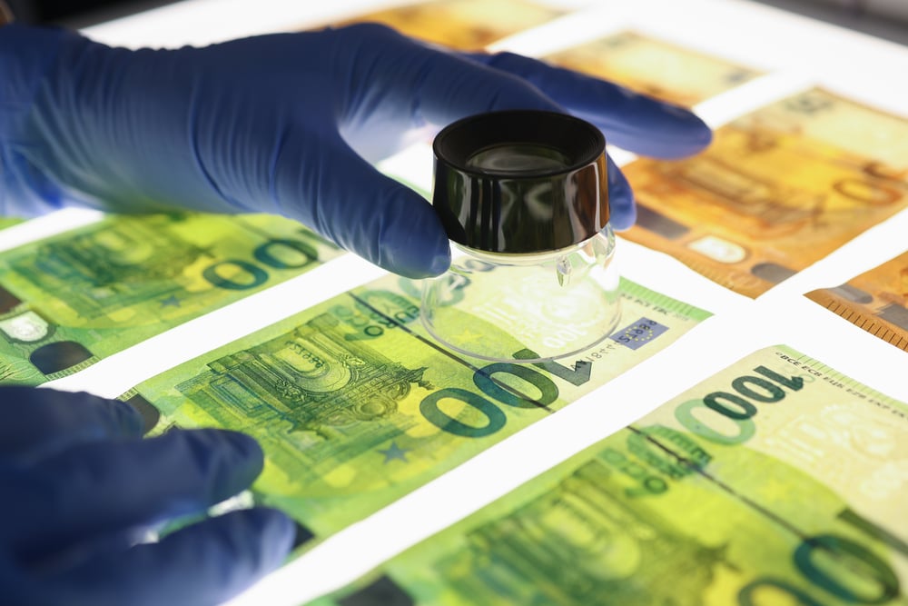 Person checking the validity of euro notes
